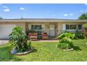 Cozy single-story home showcasing a brick accent, front porch seating, and neat landscaping at 2518 Keen Park Dr, Largo, FL 33771