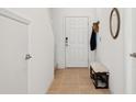 Bright entryway with clean, neutral decor, tiled floor, coat hooks, bench and ample lighting at 34196 Polacca Ln, Wesley Chapel, FL 33543