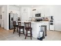Bright kitchen with white cabinets, stainless steel appliances, and a quartz countertop island with seating at 34196 Polacca Ln, Wesley Chapel, FL 33543