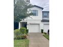 Charming townhome featuring a one-car garage, lovely landscaping, and light-colored exterior at 3926 Cat Mint St, Tampa, FL 33619