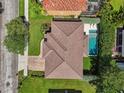 Aerial view of a private backyard with a sparkling pool, manicured landscaping, and a tile roof at 4012 W Obispo St, Tampa, FL 33629