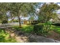 Charming bungalow with lush landscaping, a well-manicured lawn, and a driveway leading to an attached single-car garage at 5135 21St Avenue N, St Petersburg, FL 33710