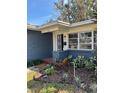 View of the home's entry showing a white framed window and nicely landscaped garden bed at 641 Geneva Pl, Tampa, FL 33606