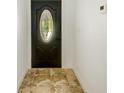 Close-up of the detailed front door with decorative glass and neutral tile flooring at 8402 Roxboro Dr, Hudson, FL 34667