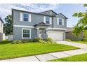 Attractive two-story home with a lush green lawn, a two-car garage, and a well-manicured garden at 10270 Shady Preserve Dr, Riverview, FL 33578