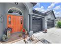 Welcoming entrance with a vibrant orange door, stone accents, and a well-kept two-car garage at 10813 Rockledge View Dr., Riverview, FL 33579
