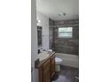 Bathroom with shower-tub combination and granite countertops and dark wood cabinets at 10918 N Boulevard, Tampa, FL 33612