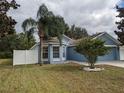 Exterior view of home with tidy front lawn and mature landscaping around bay window at 12216 Southbridge Ter, Hudson, FL 34669