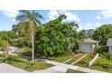 Single-story home with a well-maintained lawn, mature landscaping and a detached garage at 1222 Palm St, Clearwater, FL 33755