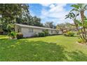 Lush front lawn with mature trees surrounding the home's exterior at 16113 Tampa St, Lutz, FL 33548