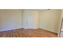 Bright living room featuring wood-look floors, neutral walls, and a large front door at 16501 Harper Pond Ln # 308, Odessa, FL 33556