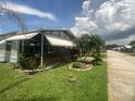 Charming home with a screened-in porch, well-manicured lawn, and palm trees, located on a quiet street at 1710 7Th Sw St # 39, Ruskin, FL 33570