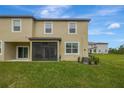 Backyard view featuring a screened lanai and a well-maintained lawn at 17741 Tawny Malt Pl, Land O Lakes, FL 34638