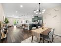 Open-concept living room and kitchen with modern furnishings, a dining area, and sleek, dark-wood floors at 1803 E Powhatan Ave, Tampa, FL 33610