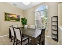 Elegant dining area with a large window and a rustic wooden table set for six at 2009 Raven Manor Dr, Dover, FL 33527