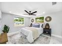 Comfortable bedroom is complete with a ceiling fan and views from the large windows at 208 Palmetto W Rd, Nokomis, FL 34275