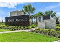 Landscaped entrance to River Landing featuring stone accents and lush landscaping at 2492 Overfalls Pl, Wesley Chapel, FL 33543