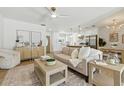 Bright, open-concept living space with hardwood floors, ceiling fan, comfortable furniture, and seamless kitchen access at 4611 W Bay Court Avenue, Tampa, FL 33611