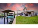 Waterfront property featuring a boat lift, tiki bar, and lush landscaping for relaxing by the canal at 108 W Saint Johns Way # 210, Apollo Beach, FL 33572