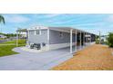 Charming home featuring a covered parking area, bench seating, and well-manicured landscaping at 108 W Saint Johns Way # 210, Apollo Beach, FL 33572
