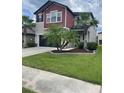 Charming two-story home with a well-manicured lawn and palm trees adding to its curb appeal at 1596 Ludington Ave, Wesley Chapel, FL 33543