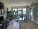 Bright kitchen featuring dark cabinetry, granite counters, and a view of the dining area at 1596 Ludington Ave, Wesley Chapel, FL 33543