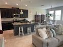 Open concept living area featuring a modern kitchen island and a cozy seating area at 1596 Ludington Ave, Wesley Chapel, FL 33543
