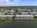 Aerial view of the community featuring lush landscaping, a lake, and tennis courts at 225 Pompano Se Dr # D, St Petersburg, FL 33705