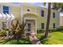 Charming yellow townhouse featuring a well-maintained lawn and decorative palm tree at 225 Pompano Se Dr # D, St Petersburg, FL 33705