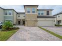 Charming townhouse exterior with a two-car garage and appealing brick-paved driveway at 2469 Stapleford Pl, Wesley Chapel, FL 33543