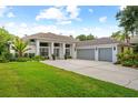 Lovely home with a three-car garage, manicured lawn, and concrete driveway at 3612 Cordgrass Dr, Valrico, FL 33596