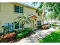 Townhouse exterior with charming front entrance, mature palm trees and green lawn at 3909 45Th W Ter # 102, Bradenton, FL 34210