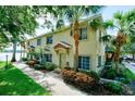 Inviting townhouse featuring landscaped pathway, swaying palm trees, and serene lakeside setting at 3909 45Th W Ter # 102, Bradenton, FL 34210