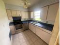 Functional kitchen featuring neutral cabinetry, stainless steel appliances, and a double sink beneath a window at 4611 W Mcelroy Ave, Tampa, FL 33611