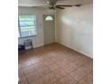Cozy living room featuring tiled floors, natural light from a window, and a classic ceiling fan at 4611 W Mcelroy Ave, Tampa, FL 33611