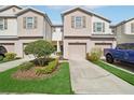 Well-maintained townhomes with a landscaped yard and individual driveways at 4935 White Sanderling Ct, Tampa, FL 33619