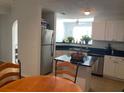 Kitchen with stainless-steel appliances, white cabinetry, and an island with seating at 501 Knights Run Ave # 2218, Tampa, FL 33602