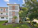Exterior view of building showcasing unique architectural details and a lush landscaped lawn with decorative plants at 6015 19Th N St # 117, St Petersburg, FL 33714