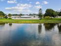 Exterior lake view with a community center surrounded by well-maintained landscaping and a pool at 6015 19Th N St # 117, St Petersburg, FL 33714