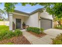 Charming home featuring a gray door with wreath, gray trim, and a two-car garage at 6218 Magnolia Park Blvd, Riverview, FL 33578