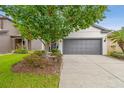 Two-car garage with gray door and a driveway lined with landscaped beds at 6218 Magnolia Park Blvd, Riverview, FL 33578