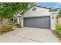 Two-car garage with gray door and a driveway lined with landscaped beds at 6218 Magnolia Park Blvd, Riverview, FL 33578