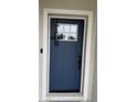 A dark blue front door features decorative trim and an electronic lock at 9397 Northcliffe Blvd, Spring Hill, FL 34606