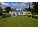 Well-manicured lawn and landscaping enhance this home's curb appeal; white picket fence adds a touch of charm at 101 N Corona Ave, Clearwater, FL 33765