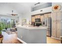 Open kitchen featuring stainless steel appliances, light wood cabinets, breakfast bar, and scenic view at 1107 Normandy Trace Rd, Tampa, FL 33602