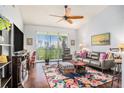 Cozy living room with ceiling fan, wood floors, a large window with blinds, and comfortable seating at 1107 Normandy Trace Rd, Tampa, FL 33602