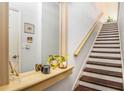 Bright staircase features wood steps, neutral walls, a wood handrail, and charming entryway decor at 1107 Normandy Trace Rd, Tampa, FL 33602