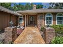 Welcoming front entrance with stylish brick pillars, a decorative walkway, and a solid wood door at 11279 Oakridge Trl, Seminole, FL 33772