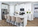 Modern kitchen with a large center island, stainless steel appliances, and sleek white cabinetry at 12574 Somatic Ct, Venice, FL 34293
