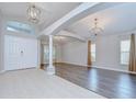 Inviting living room with tile and wood floors, elegant chandeliers, and neutral paint at 15126 Shearcrest Dr, Lithia, FL 33547